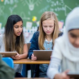 Kids using tablets in a schoolroom setting 1x1 CROP