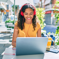 Teen girl using laptop with red headphones 1x1 CROP-1