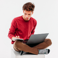 Teenage boy sitting with laptop and tablet 1x1 CROP